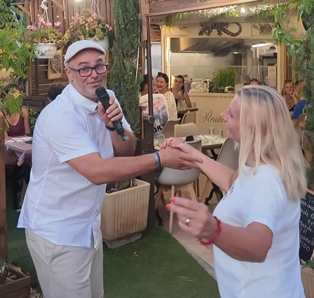 Cédric chantant avec une participante en terrasse